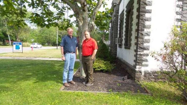 Ken Thiele, PennDOT's maintenance manager for Pike County, and Chuck DeFebo, PennDOT's business manager for Pike County, stand under a cucumbertree outside their Milford office. (Photo by Frances Ruth Harris)