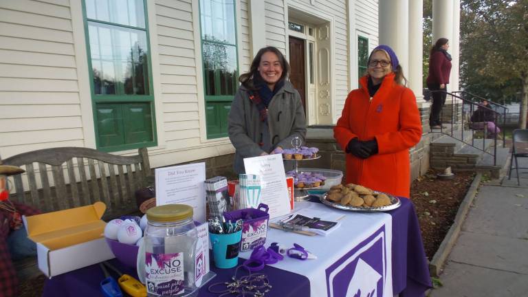 Safe Haven's Stacey Pitch and Carol Witschel standing near one of Safe Haven's many displays on Milford's Community House (Photo by Frances Ruth Harris)