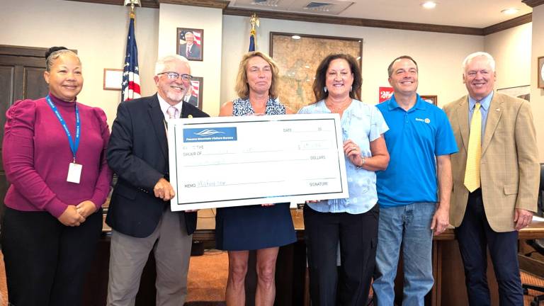Commissioners stand with check to the Lions Club for the Milford Star.