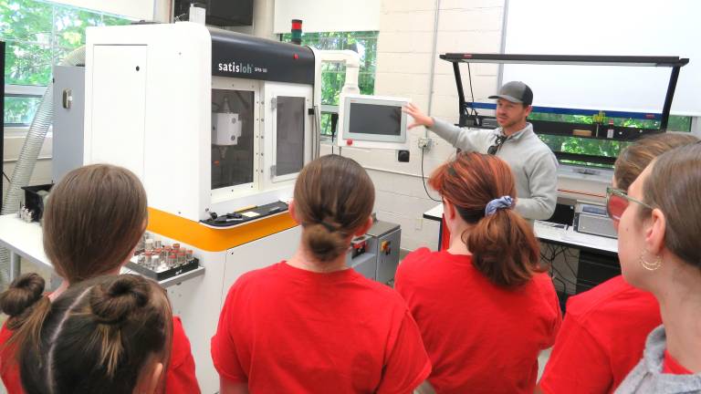 DVE-News/TV reporters looking at the optic machinery with Mr. Jack Stafford.