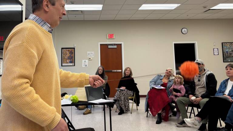 David Richard reciting a poem holding a Poi, an ancient Maori object used to help keep the rhythm of presenting a poem or story.