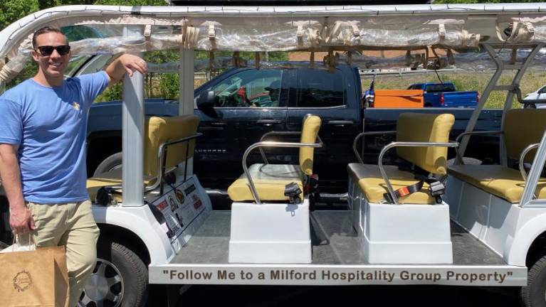 Steven Rosado, Director of Development for the Milford Hospitality Group, with the Jolly Trolley.